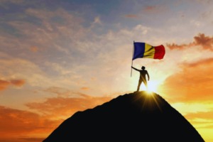 Person waving a flag on top of the mountain