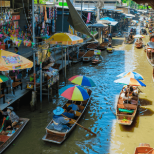 Vibrant boats navigate the lively waters of a traditional floating market, showcasing a colorful tapestry of culture, flavors, and local life