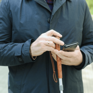 Visually impaired man holding a cane and a smartphone