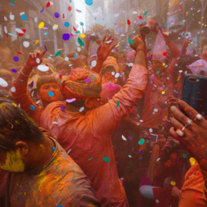 A crowd of people celebrating the festival of colors and spreading colored powder