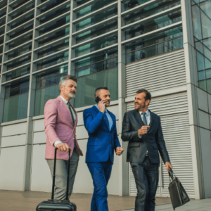 A group of businessman carrying their bags and one holding his phone