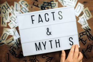 Facts and Myths on lightbox with a hand on it