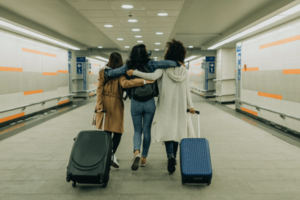 Three friends with suitcases travel together