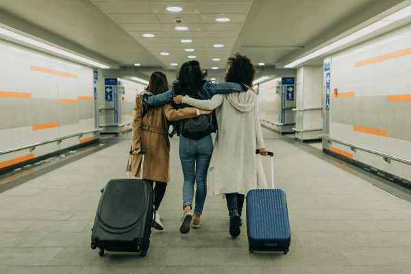 Three friends with suitcases travel together