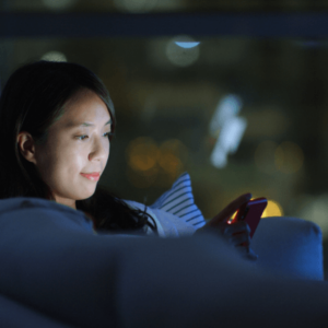A woman using her smartphone at night