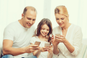 Parents with their daughter using smartphone