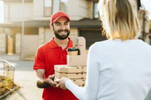 Smiling delivery man giving food order to his customer