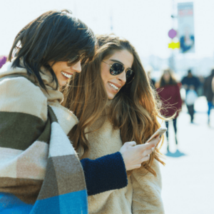 Smiling travelers using mobile phone