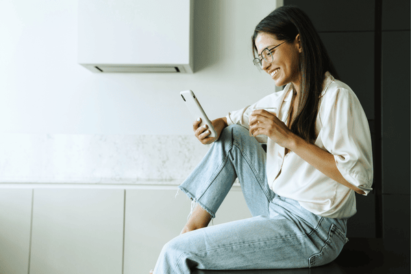 Smiling Young Woman Using Mobile Phone