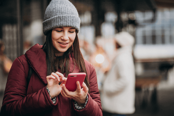 Girl using phone outside the street and meeting with friends