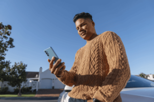 Low angle man using smartphone outdoors
