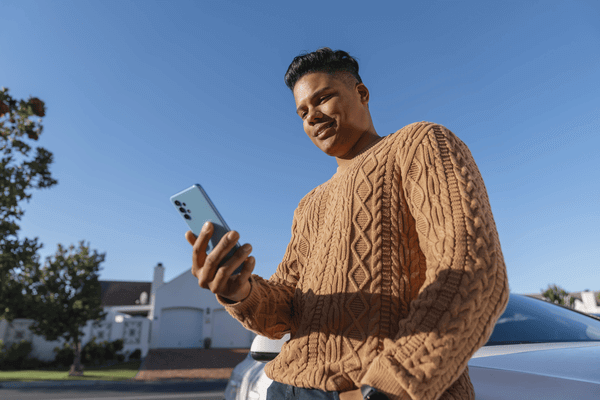Low angle man using smartphone outdoors