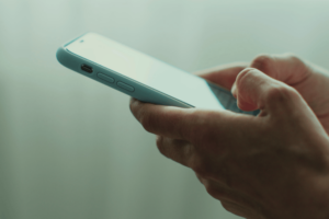 Hand of woman using texting mobile phone or chat.