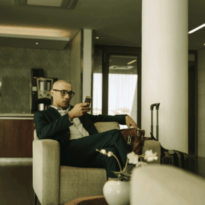 Business Traveler Waiting in Airport Lounge Using Phone
