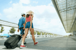 Couple Near Airport With Suitcase Traveling In Summer