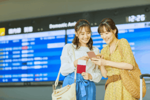 Friends Checking Their Travel Plans at an Airport