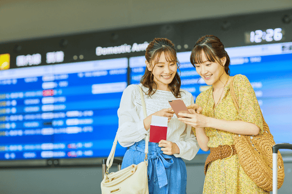 Friends Checking Their Travel Plans at an Airport