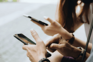 Friends Sitting in the Park Using Hands Modern Smartphone