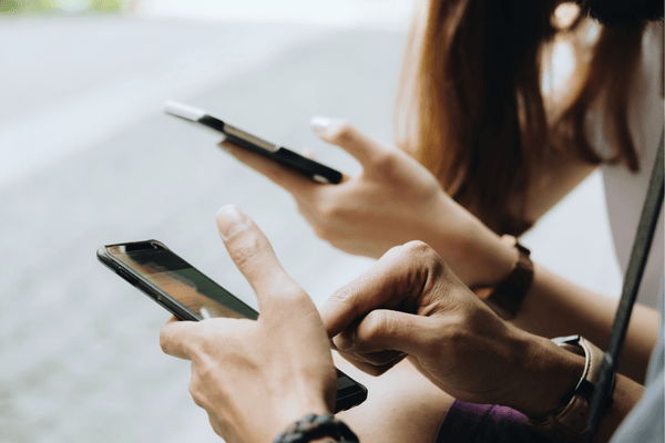 Friends Sitting in the Park Using Hands Modern Smartphone