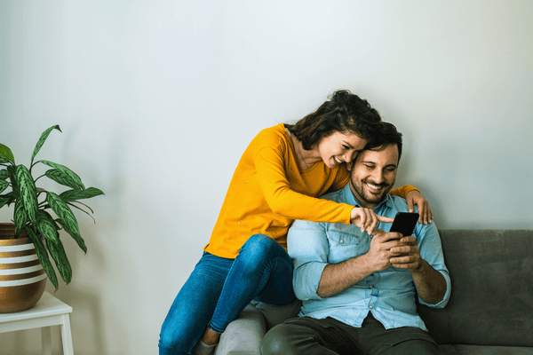 Happy couple using phone