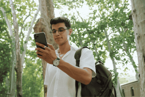 Man Using Phone Among Trees