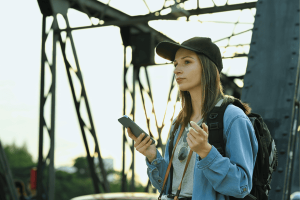 Portrait of hipster woman traveler using mobile phone