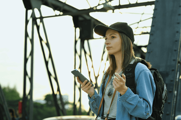 Portrait of hipster woman traveler using mobile phone