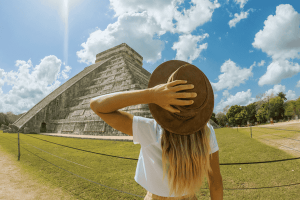 Travel girl contemplating Chichen Itza pyramid, Mexico