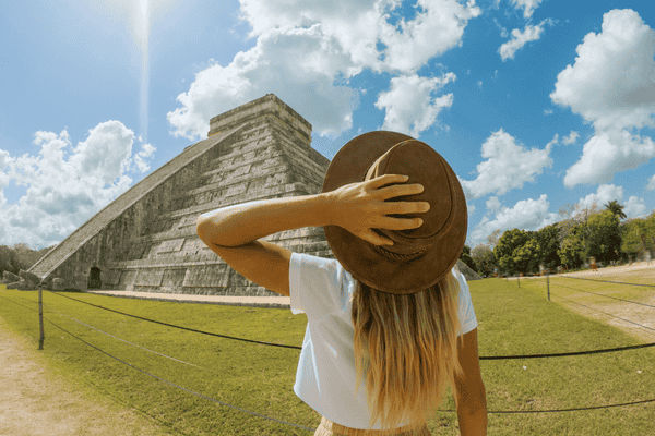 Travel girl contemplating Chichen Itza pyramid, Mexico