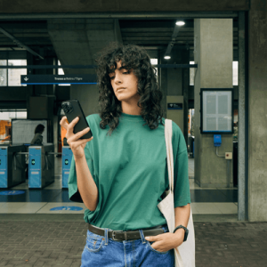 Woman Using Phone at a Train Station