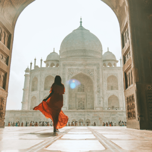 Woman in Red Dress Standing in Front of Taj Mahal