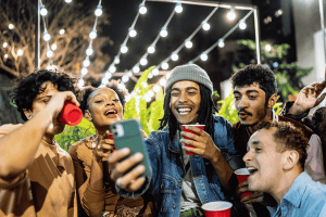 Friends using mobile phone in the street at night