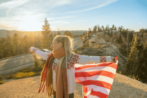 Girl traveling in USA holding American flag in the air