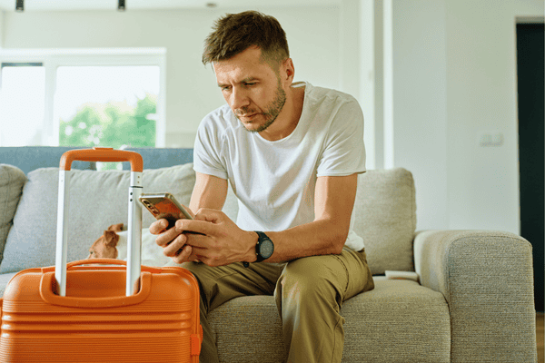Man Checking Phone Before Travel with Dog