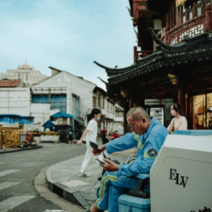 Man Relaxing on an Urban Street Corner in Shanghai