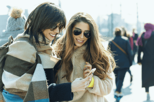 Smiling travelers using mobile phone