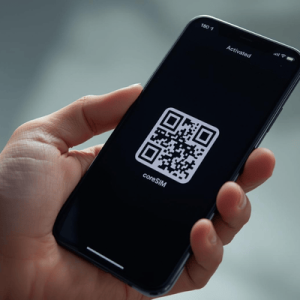 a hand holding a smartphone with activated eSIM QR code