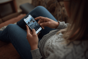 a person sitting on a couch using a smartphone