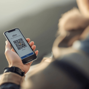 a traveler holding a smartphone with eSIM QR activated