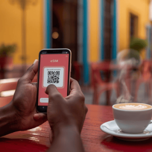 Close-up of a smartphone screen displaying a QR code for eSIM Mexico activation at a sunny outdoor cafe