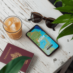 Flat-lay of travel essentials in a Bangkok café featuring a smartphone showing a successfully activated Thailand eSIM