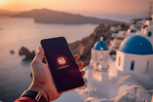 A traveler using 5G data on a smartphone overlooking the blue domes of Santorini, Greece, representing Terminal eSIM connectivity